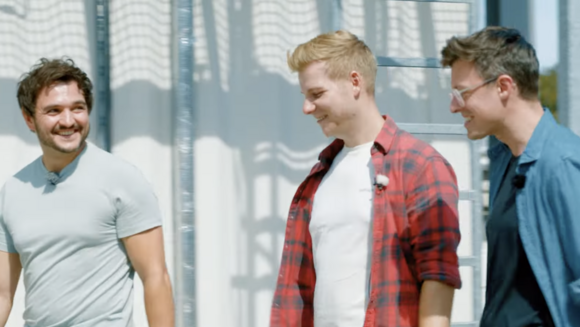 Drei Personen gehen im Sonnenschein nebeneinander her