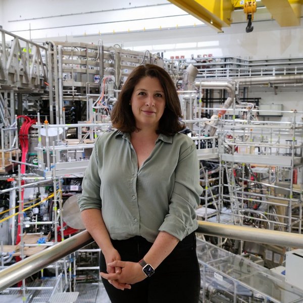 Prof. Josefine Proll steht vor einem Geländer in einem Maschinenraum
