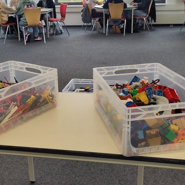 Zwei Boxen mit Bausteinen stehen auf einem Tisch im Klassenzimmer.
