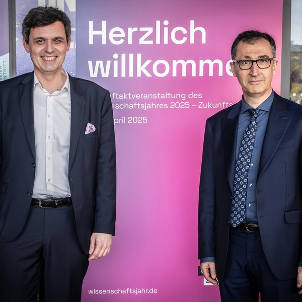 Dr. Stefan Brandt, Direktor des Futuriums, und Cem Özdemir, Bundesminister für Bildung und Forschung, stehen vor einem Roll-up mit der Aufschrift "Herzlich willkommen".