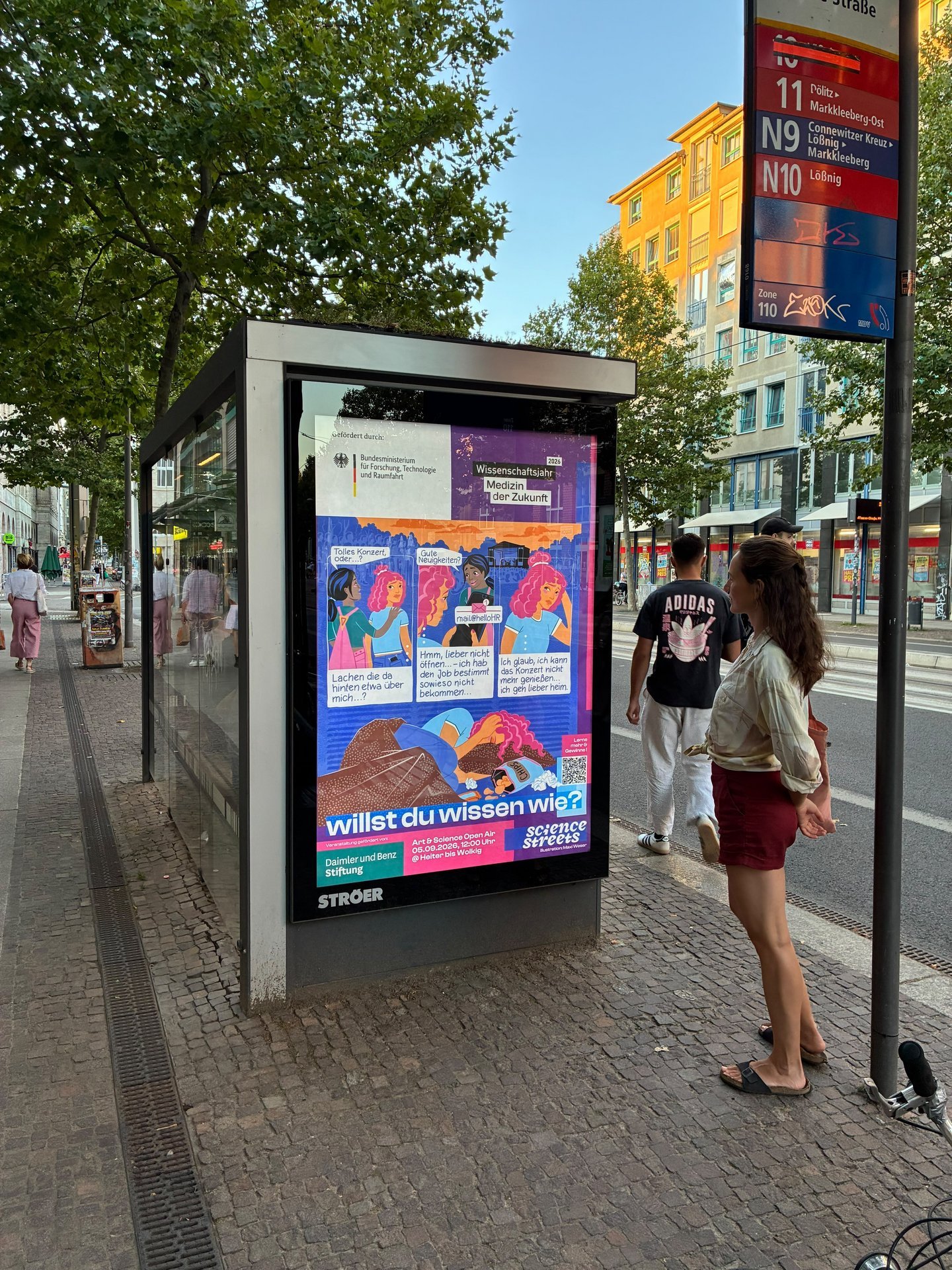 Eine Frau betrachtet ein Comic zur Gehirngesundheit auf einer digitalen Anzeigetafel.
