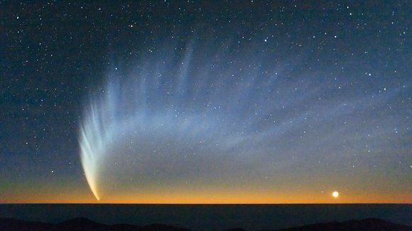 Ein Komet mit gewaltigem Schweif am Nachthimmel über dem Meer